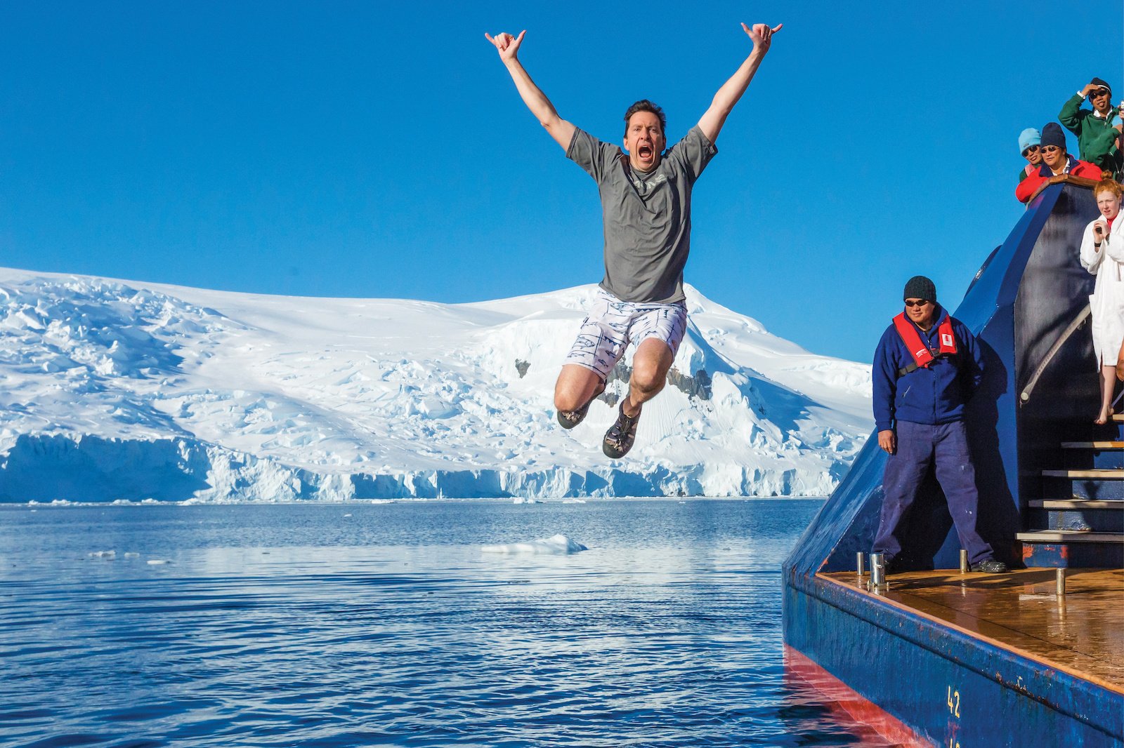 A man jumps into the polar waters on a Lindblad-National Geographic expedition